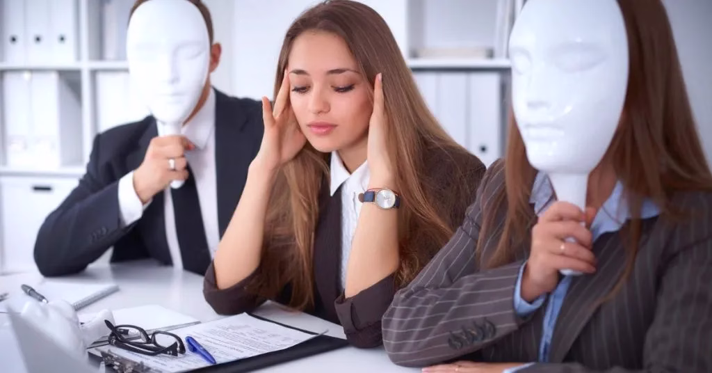 Mulher com mãos na cabeça sofrendo emocionalmente, cercada por pessoas com máscaras brancas sem expressão, simbolizando as máscaras emocionais criadas pelas 5 feridas da alma na Senzala Emocional